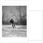 1940s man playing ice hockey on frozen lake controlling puck with stick by Anonymous