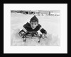 1950s boy on sled in snow looking at camera by Anonymous