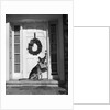 1930s german shepherd dog sitting front door stoop porch holding christmas package in his mouth by Anonymous