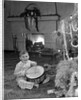1950s little boy playing toy drum by christmas tree and fireplace looking at camera by Anonymous