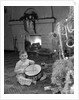 1950s little boy playing toy drum by christmas tree and fireplace looking at camera by Anonymous