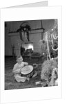 1950s little boy playing toy drum by christmas tree and fireplace looking at camera by Anonymous