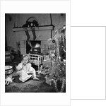 1950s smiling little girl christmas tree talking on toy telephone by Anonymous