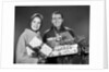 1960s smiling couple man and woman holding wrapped christmas presents and packages by Anonymous