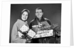 1960s smiling couple man and woman holding wrapped christmas presents and packages by Anonymous