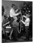 1960s family father mother two sons trimming christmas tree with string of popcorn by Anonymous