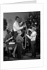1960s family father mother two sons trimming christmas tree with string of popcorn by Anonymous