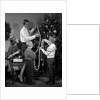1960s family father mother two sons trimming christmas tree with string of popcorn by Anonymous