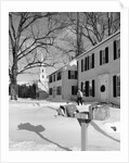 1960s woman walking to rural mailbox in front of home in snow piled with christmas packages by Anonymous