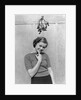 1930s 1940s cute young woman standing under mistletoe smiling hand near mouth looking at camera by Anonymous