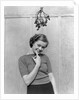 1930s 1940s cute young woman standing under mistletoe smiling hand near mouth looking at camera by Anonymous