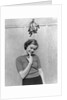 1930s 1940s cute young woman standing under mistletoe smiling hand near mouth looking at camera by Anonymous