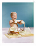 1960s baby surprised facial expression holding telephone hand set over yellow pages phone book directory by Anonymous