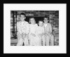 Siblings perch on a hearth in pajamas, ca. 1970. by Anonymous