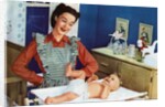 1940s Mother with Her Baby on a Changing Table in a Nursery. by Anonymous