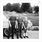 A lineup of kids by the family car. 1965. by Anonymous