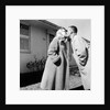 Young husband and wife kiss, ca. 1955. by Anonymous