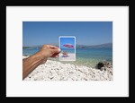 Hand holding photograph depicting deck chair and sunshade, Lumbarda, Korcula island, Croatia by Anonymous