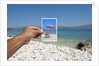 Hand holding photograph depicting deck chair and sunshade, Lumbarda, Korcula island, Croatia by Anonymous