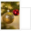 Close-up of a golden hanging Christmas bauble on blurred tree by Anonymous