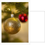 Close-up of a golden hanging Christmas bauble on blurred tree by Anonymous