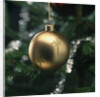 Close-up of a golden hanging Christmas bauble on blurred tree by Anonymous