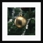 Close-up of a golden hanging Christmas bauble on blurred tree by Anonymous