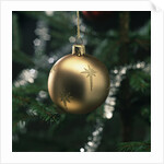 Close-up of a golden hanging Christmas bauble on blurred tree by Anonymous