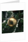 Close-up of a golden hanging Christmas bauble on blurred tree by Anonymous