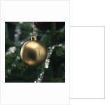 Close-up of a golden hanging Christmas bauble on blurred tree by Anonymous