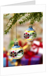 Close-up of decorated hanging baubles against blurred gifts in the background by Anonymous