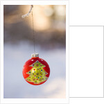 Close-up of golden Christmas tree on red bauble against blurred background by Anonymous