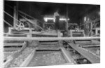 A worker stands over a rock or gravel processing facility, ca. 1910 by Anonymous