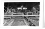 A worker stands over a rock or gravel processing facility, ca. 1910 by Anonymous