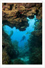 Diver seen through opening in coral reef by Anonymous