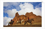 Riders passing under the Red Rock Hills of the Big Horn Mountains by Anonymous
