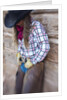 Cowgirl outside cabin by Anonymous