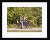 1970s Family On Tandem Bicycle Mother Father Son & Baby Daughter In Backpack Wearing Bellbottom Blue Jeans Looking At Camera by Anonymous