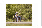 1970s Family On Tandem Bicycle Mother Father Son & Baby Daughter In Backpack Wearing Bellbottom Blue Jeans Looking At Camera by Anonymous