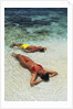 1990s Couple Sunbathing In Shallow Water At The Ocean's Edge by Anonymous