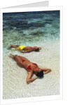 1990s Couple Sunbathing In Shallow Water At The Ocean's Edge by Anonymous