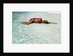 1990s Woman In Red Bikini Lying In Shallow Water On The Beach by Anonymous