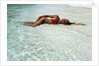 1990s Woman In Red Bikini Lying In Shallow Water On The Beach by Anonymous