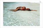 1990s Woman In Red Bikini Lying In Shallow Water On The Beach by Anonymous