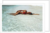 1990s Woman In Red Bikini Lying In Shallow Water On The Beach by Anonymous