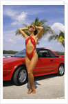 1980s Woman In Red Swimsuit In Front Of Red Sports Car by Anonymous