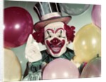 1950s Circus Clown Portrait Smiling Amid Balloons Pointing Up Looking At Camera by Anonymous
