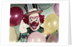 1950s Circus Clown Portrait Smiling Amid Balloons Pointing Up Looking At Camera by Anonymous