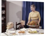 1960s Grandmother Presenting Roasted Turkey To Children At Dining Room Table by Anonymous
