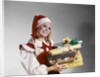 1960s Young Woman In Red And White Santa Helper Costume And Hat Holding Pile Of Wrapped Christmas Presents Studio by Anonymous